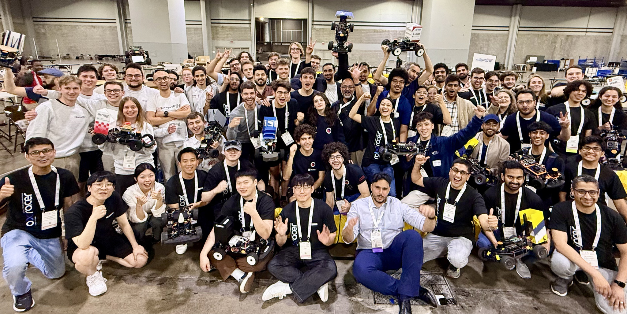 Roboracer participants holding their autonomous cars at ICRA 2025 in Atlanta.