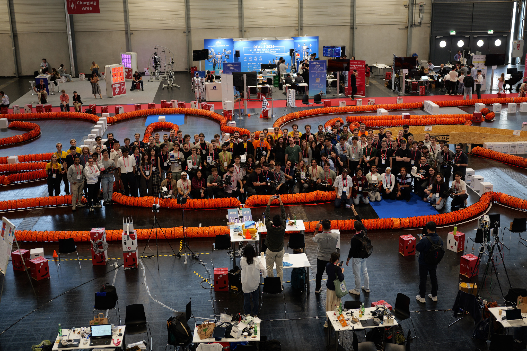 A large group of Roboracer participants beside the track at ICRA 2026 in Vienna.